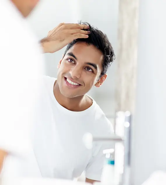 Guy in mirror | Hair Restoration | Aesthetica Med Spa In Austin, TX